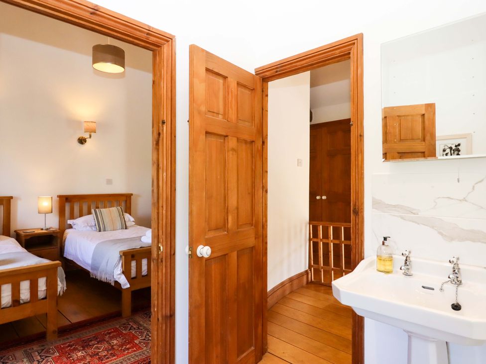 A bedroom with two beds and a sink at Oak Tree in Halwell