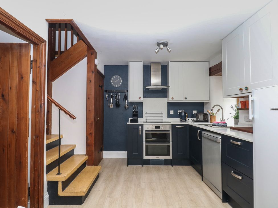 A kitchen with appliances and cabinets at Fixit Cottage in Kingsbridge