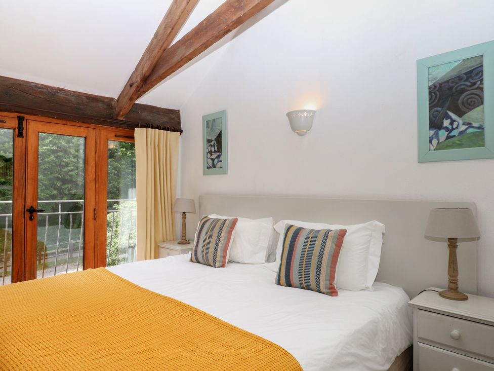 A bedroom with a bed and two bedside tables at Fixit Cottage in Kingsbridge