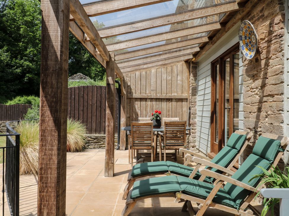 An outdoor seating area with chairs and a table at Fixit Cottage in Kingsbridge