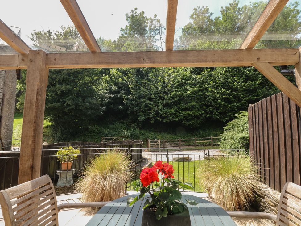 An outdoor patio with a table and chairs at Fixit Cottage in Kingsbridge