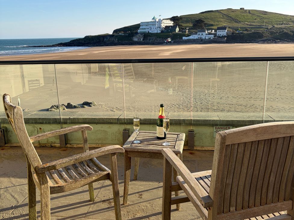 An outdoor area with chairs and a table overlooking a beach at 5 Burgh Island Causeway Bigbury-on-Sea