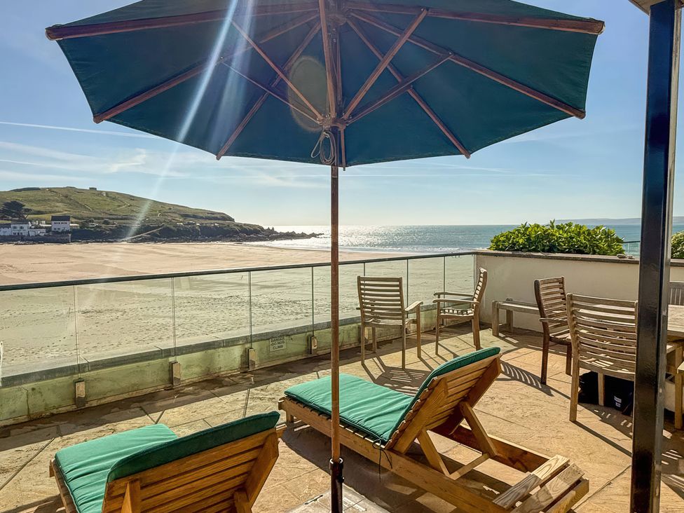 An outdoor terrace with sun loungers and a view of the sea at 5 Burgh Island Causeway Bigbury-on-Sea