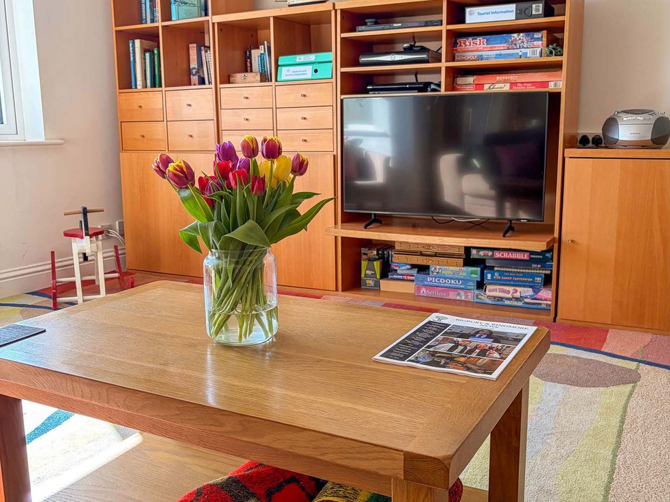 A living room with a coffee table and vase of tulips at 5 Burgh Island Causeway Bigbury-on-Sea