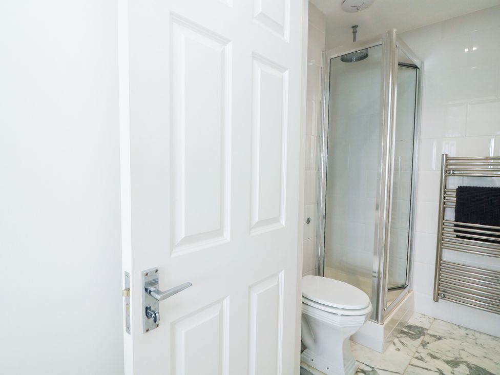 A bathroom with a shower, toilet, and towel rail at 27 Burgh Island Causeway Bigbury-on-Sea