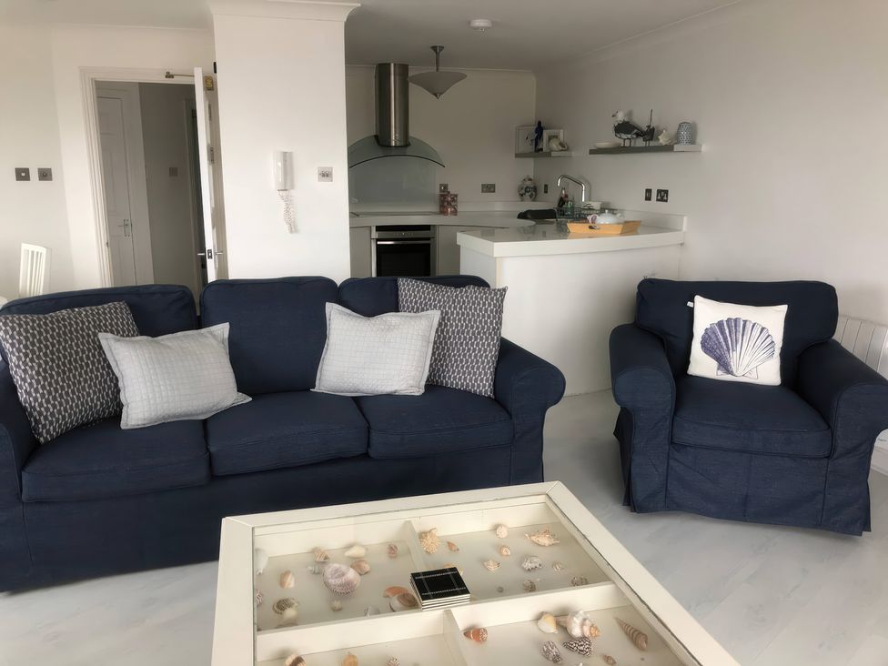 A living room with a sofa and armchair in 27 Burgh Island Causeway Bigbury-on-Sea