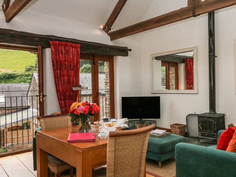 A living room with a dining table and television at Mixit Cottage in Kingsbridge