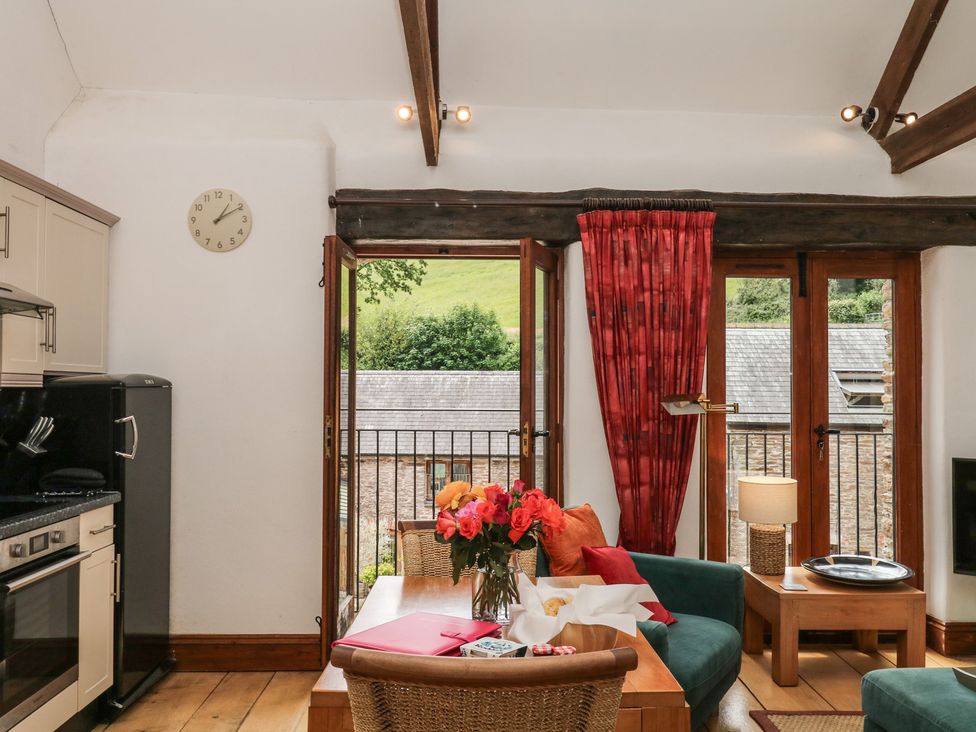 A living room with kitchen unit and open view at Mixit Cottage in Kingsbridge