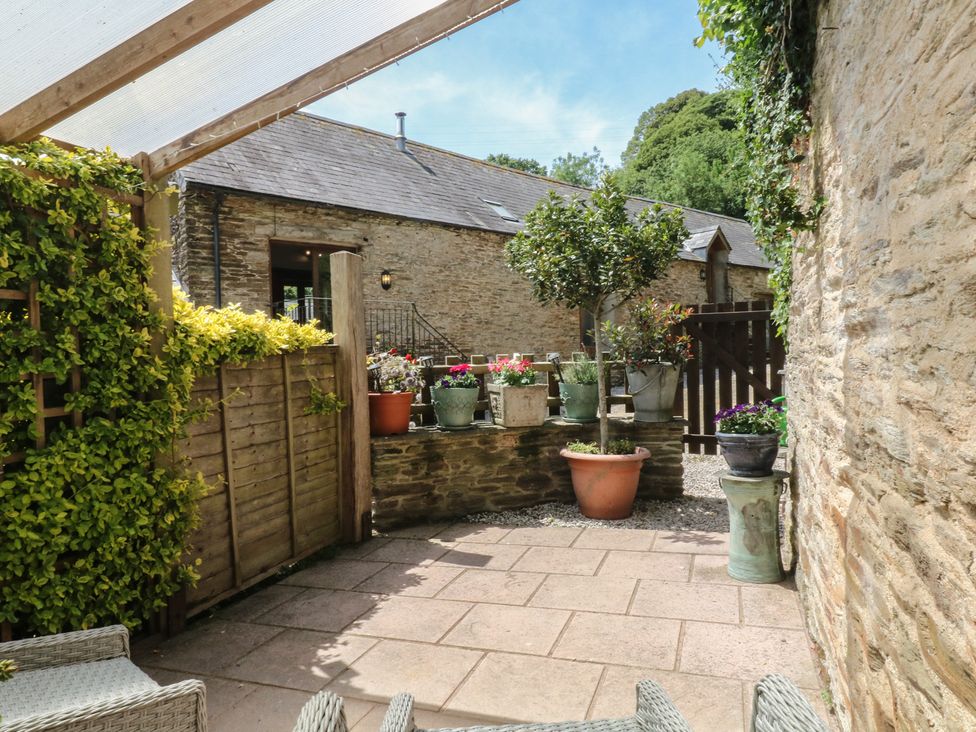 A garden with paving stones and flower pots at Mixit Cottage in Kingsbridge
