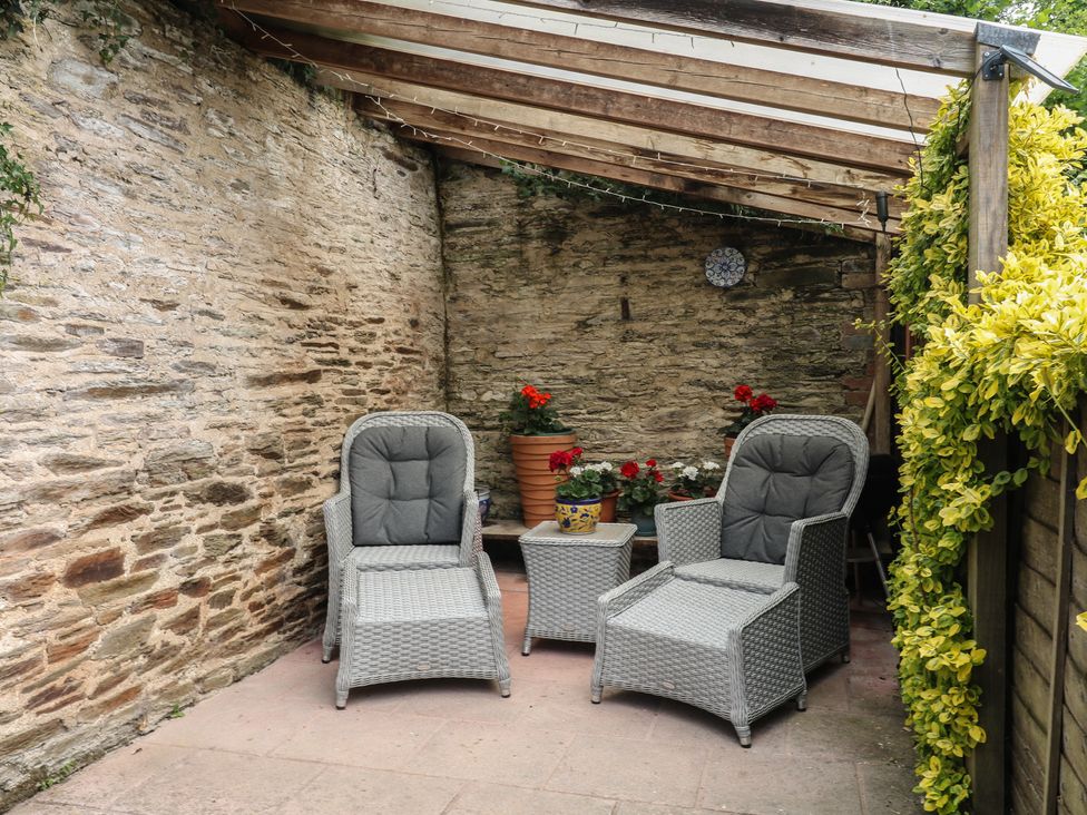 An outdoor patio with two chairs and a small table at Mixit Cottage in Kingsbridge