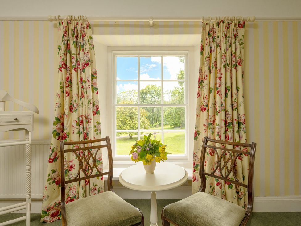 A sitting room with chairs and a table near a window at Parnacott in Holsworthy