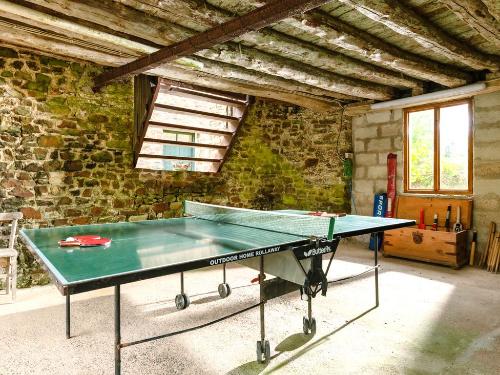 A game room with a table tennis table and stone walls at Parnacott in Holsworth