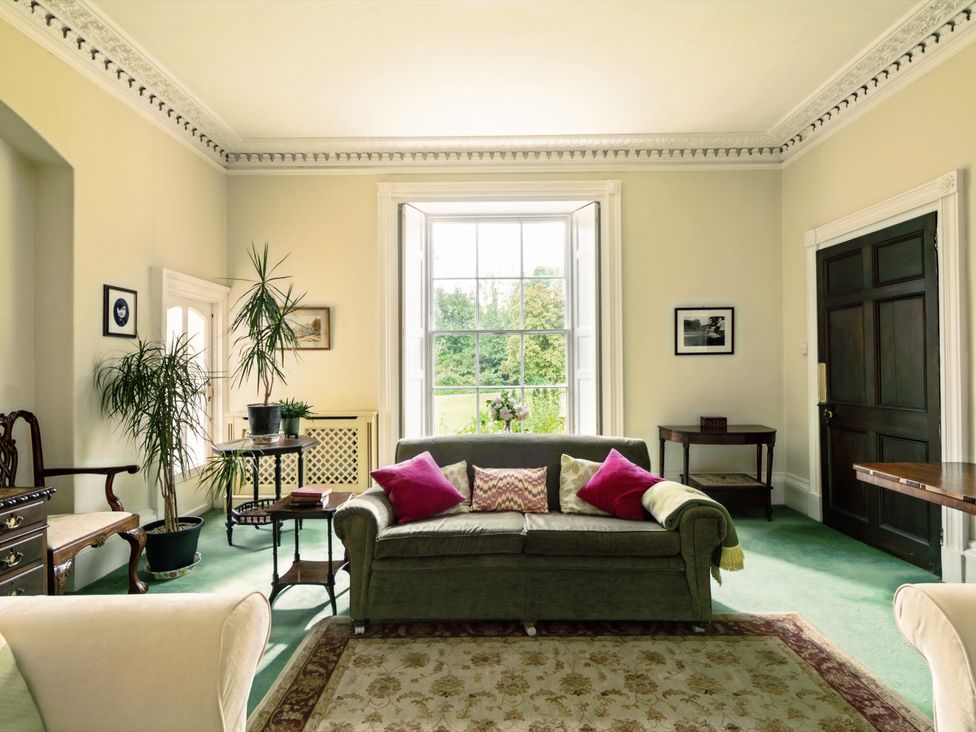 A living room featuring a sofa, table, and plants at Parnacott in Holsworthy
