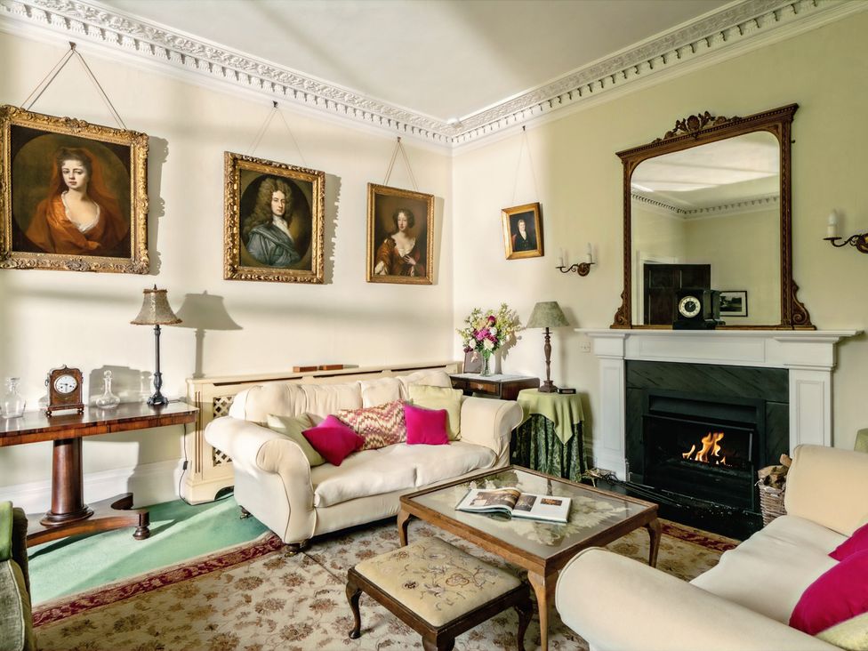 A living room with paintings and a fireplace at Parnacott in Holsworthy