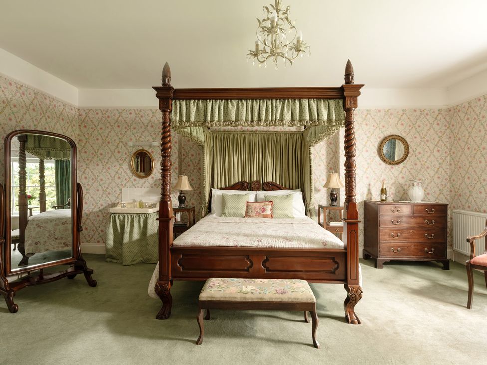 A bedroom with a four-poster bed and furniture at Parnacott in Holsworthy
