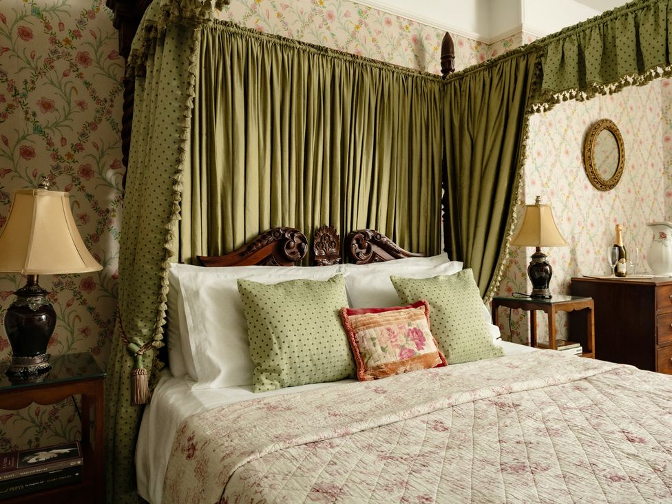 A bedroom with a four-poster bed and decorative elements at Parnacott Holsworthy
