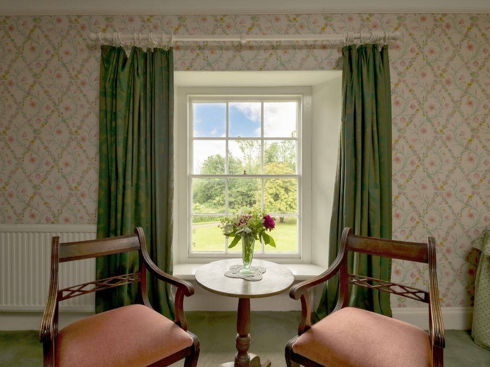 A seating area with two chairs and a table by a window at Parnacott Holsworth