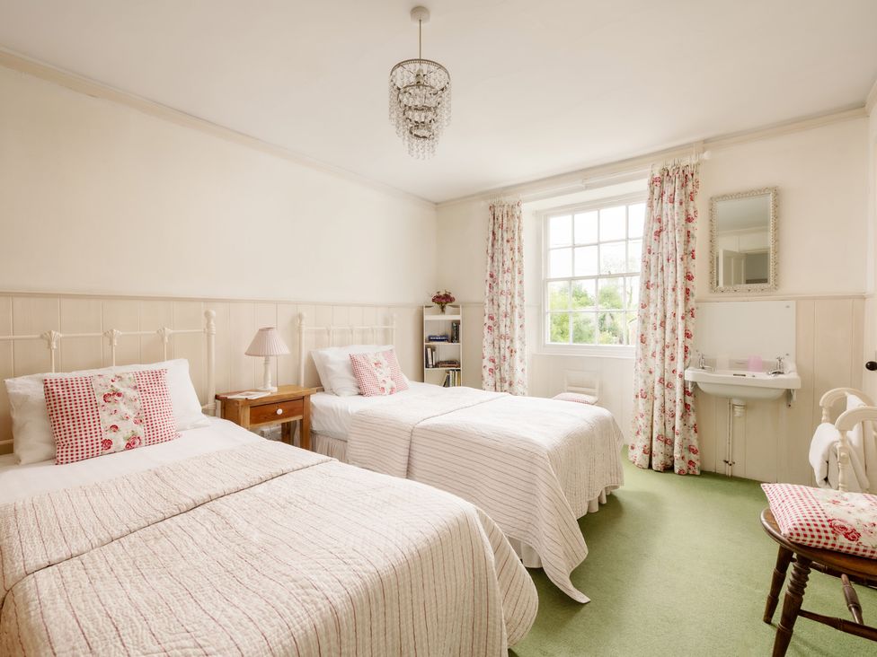 A bedroom with two beds and a washbasin at Parnacott in Holsworthy