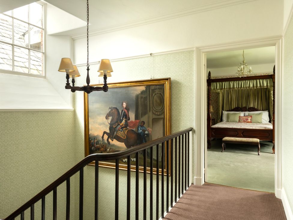 A staircase with a painting and a view of a bedroom at Parnacott in Holsworthy