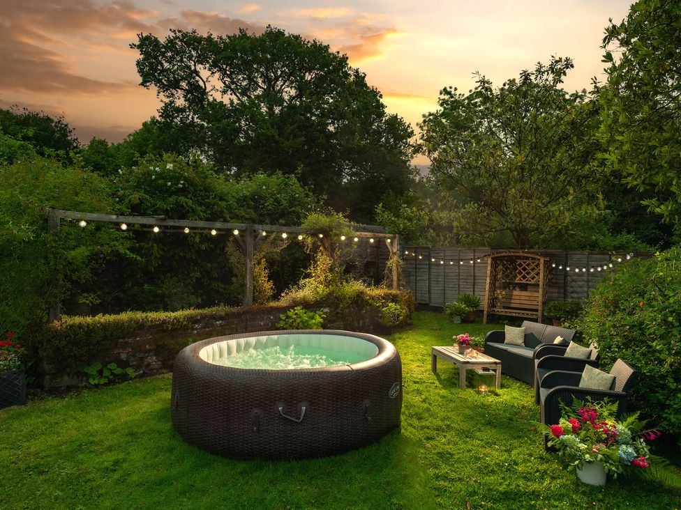 A hot tub and seating area in a garden at Parnacott in Holsworthy