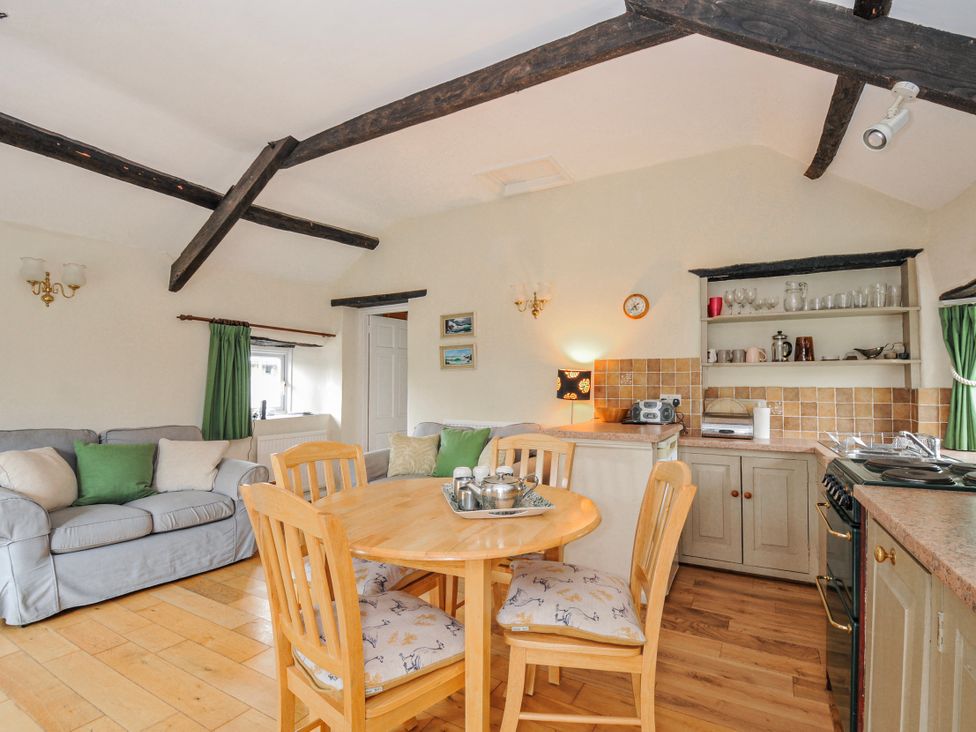 A kitchen with a dining area and seating at Tumrose Cottage in Blisland