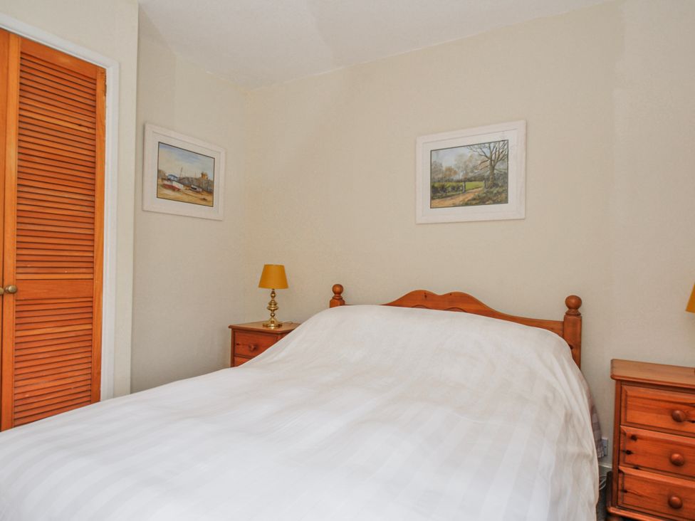 A bedroom with a bed and nightstands at Tumrose Cottage Blisland