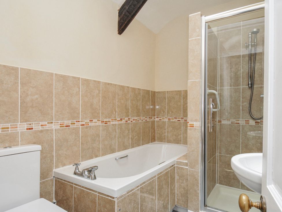 A bathroom with a bathtub, shower, toilet and sink at Tumrose Cottage in Blisland