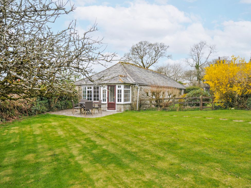 A cottage with chairs and a table in the garden at Tumrose Cottage Blisland