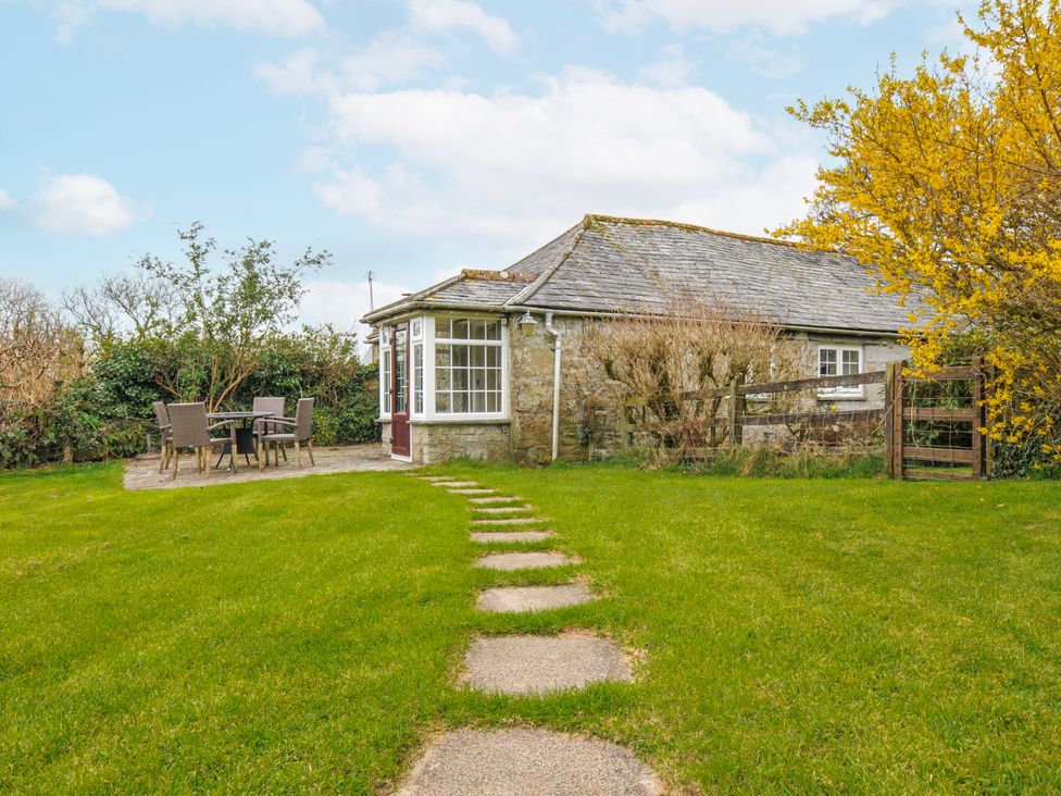 A cottage with furniture and a pathway in Blisland