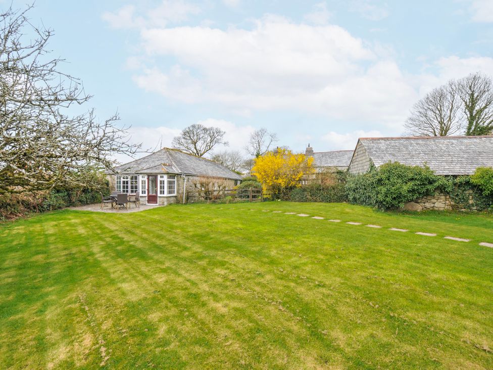 A garden with a pathway and shed at Tumrose Cottage in Blisland