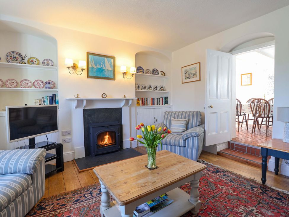 A living room with a fireplace and seating area at Agar Cottage Trelights near Port Isaac