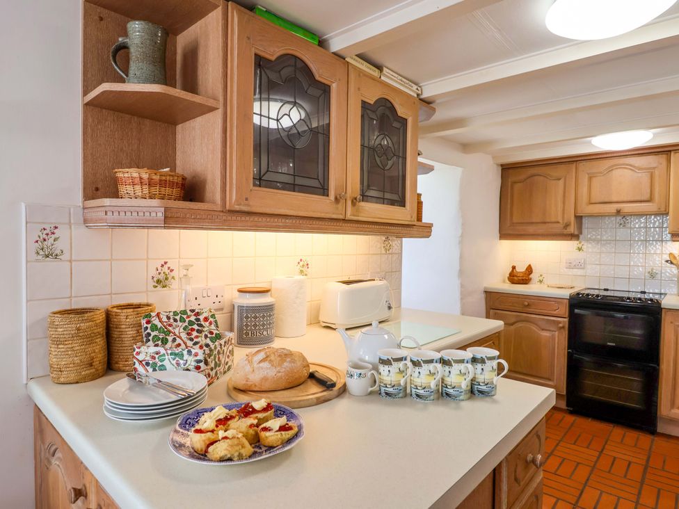 A kitchen with a countertop displaying baked goods and kitchen appliances at Agar Cottage, Trelights, near Port Isaac