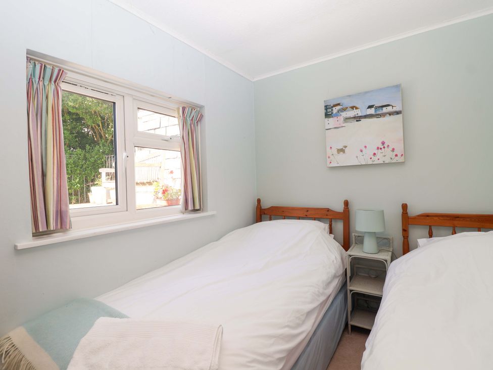 A bedroom with two single beds and a window at Agar Cottage, Trelights, near Port Isaac