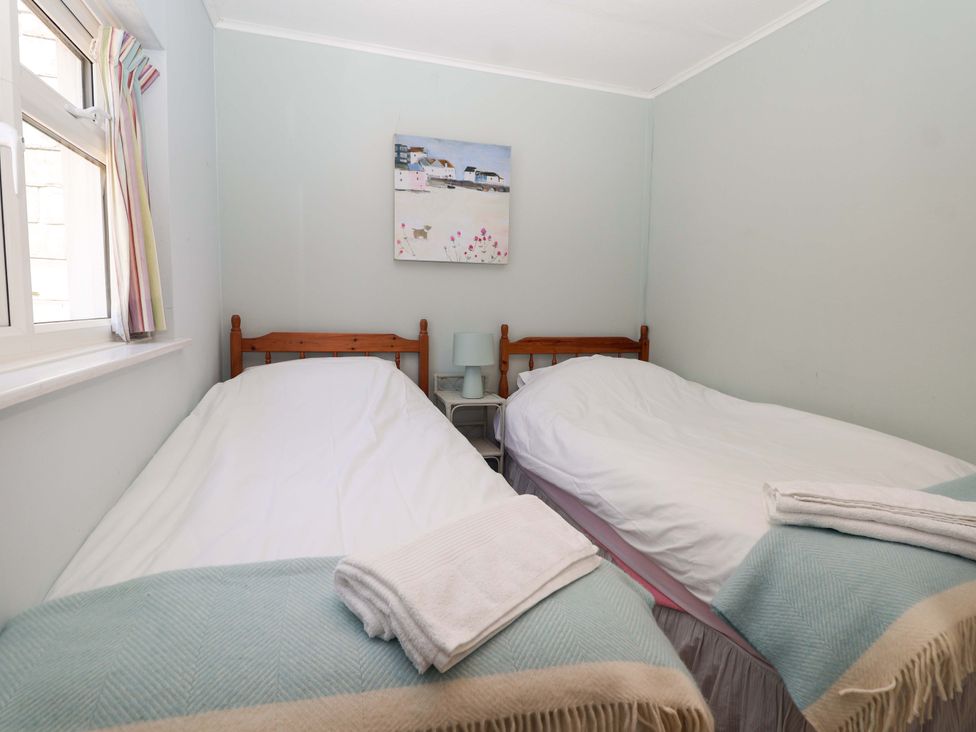 A bedroom with twin beds and a bedside table at Agar Cottage, Trelights, near Port Isaac