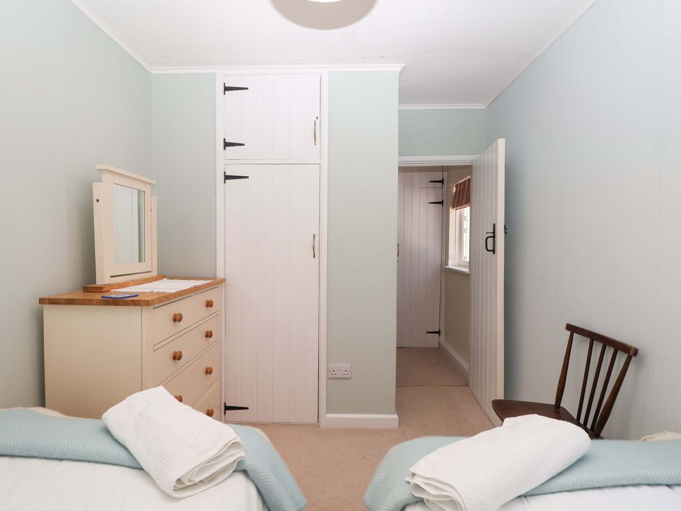 A bedroom with a dresser and mirror at Agar Cottage in Trelights, near Port Isaac