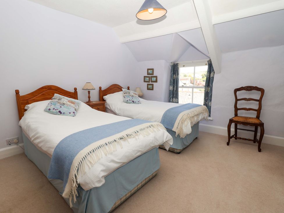 A bedroom with two beds and an armchair at Agar Cottage Trelights near Port Isaac