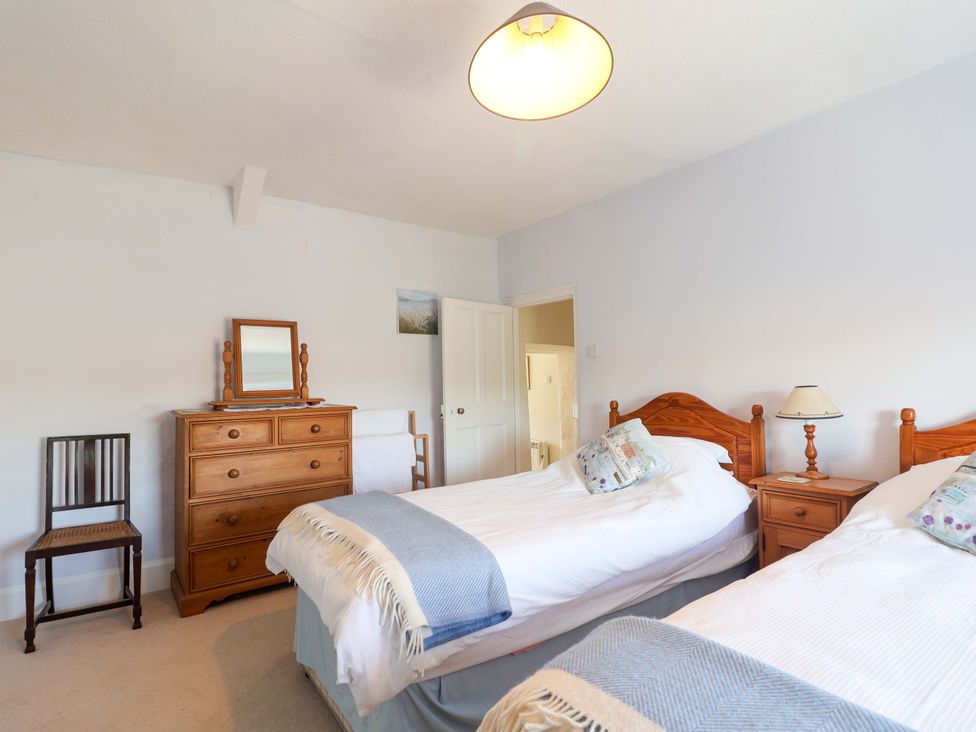 A bedroom with two beds and a dresser at Agar Cottage, Trelights, near Port Isaac