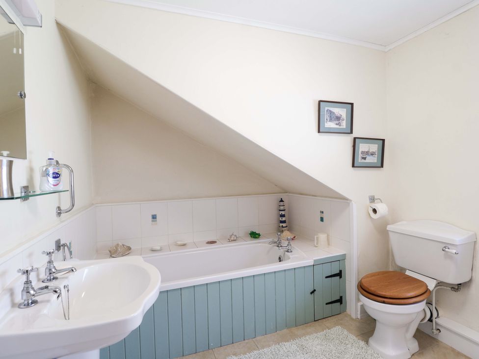 A bathroom with a bath tub and sink at Agar Cottage in Trelights, near Port Isaac