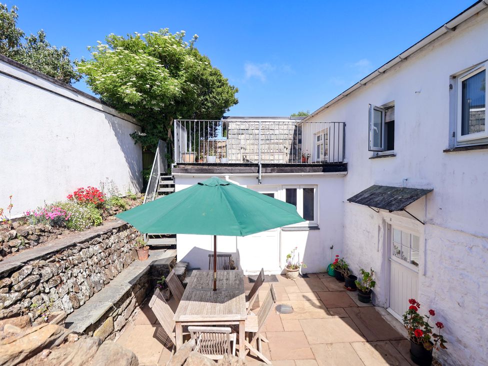 An outdoor seating area with a table and chairs at Agar Cottage Trelights near Port Isaac