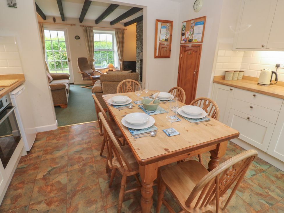 A dining room with a table set for meals at Primrose Cottage Edmonton, near Wadebridge