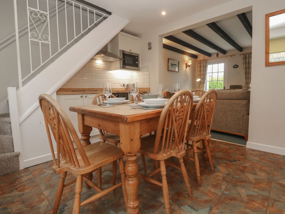 A dining area with a table and chairs at Primrose Cottage in Edmonton, near Wadebridge