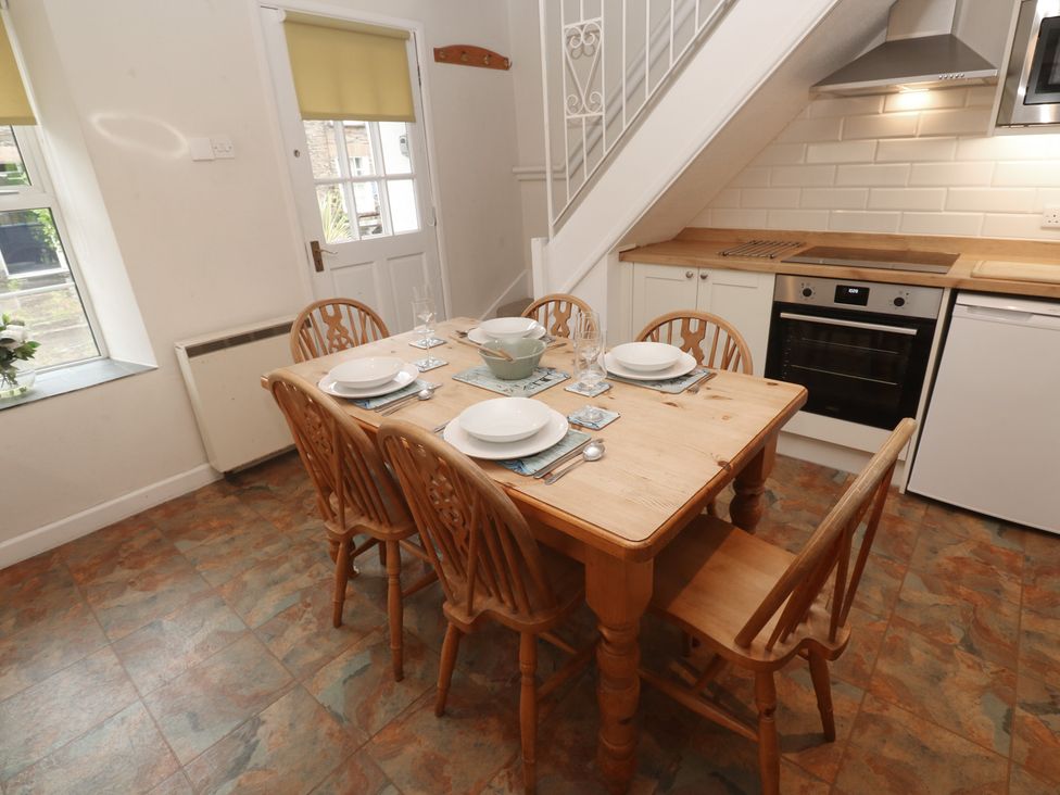 A kitchen with a dining table and chairs at Primrose Cottage in Edmonton, near Wadebridge