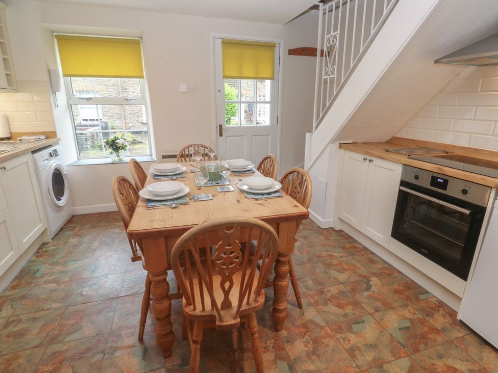 A dining room with a table and chairs at Primrose Cottage, Edmonton, near Wadebridge