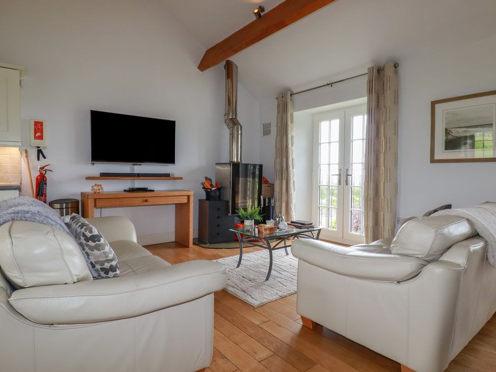 A living room with a sofa and television at Atlantic View in Tintagel