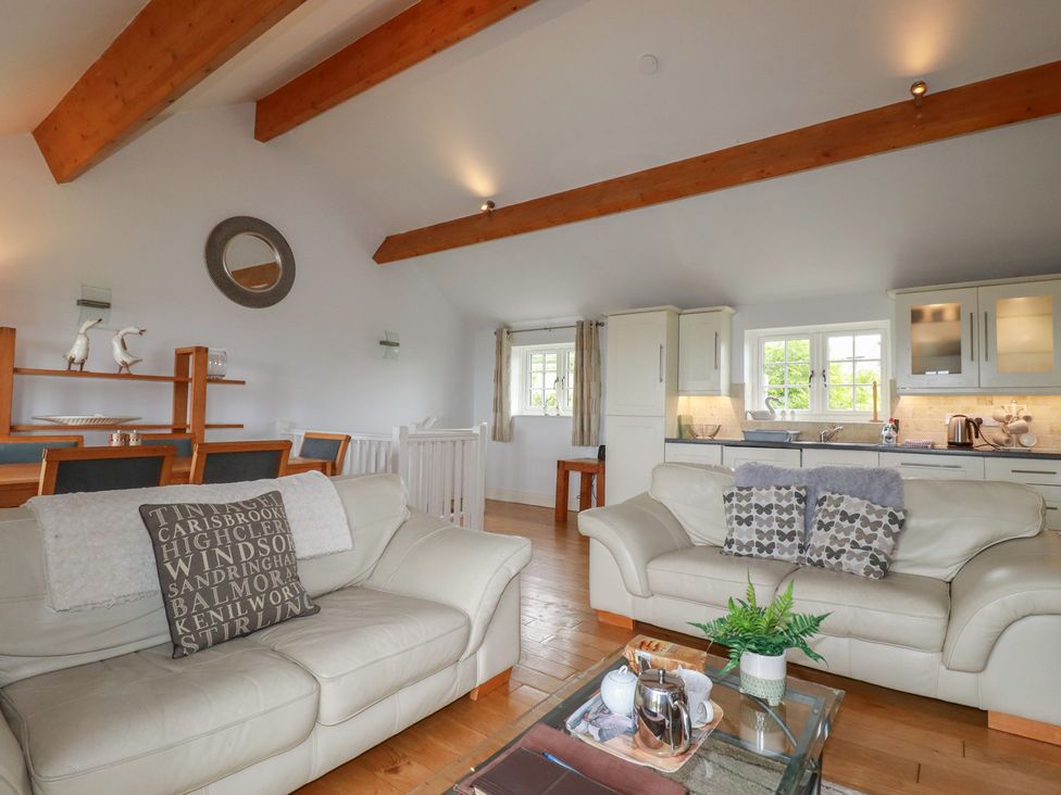 A living room with a sofa and dining table at Atlantic View in Tintagel