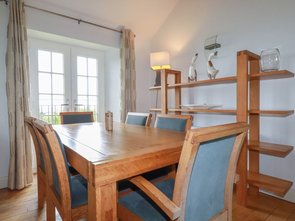 A dining room with a wooden table and chairs at Atlantic View in Tintagel