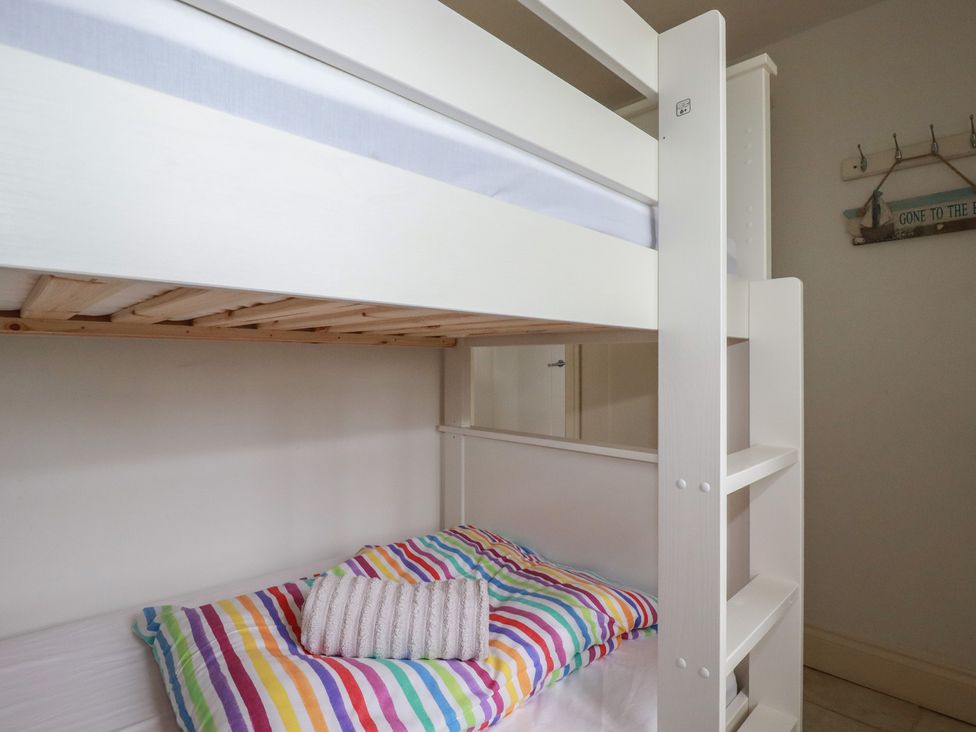 A bunk bed with striped bedding at Atlantic View in Tintagel