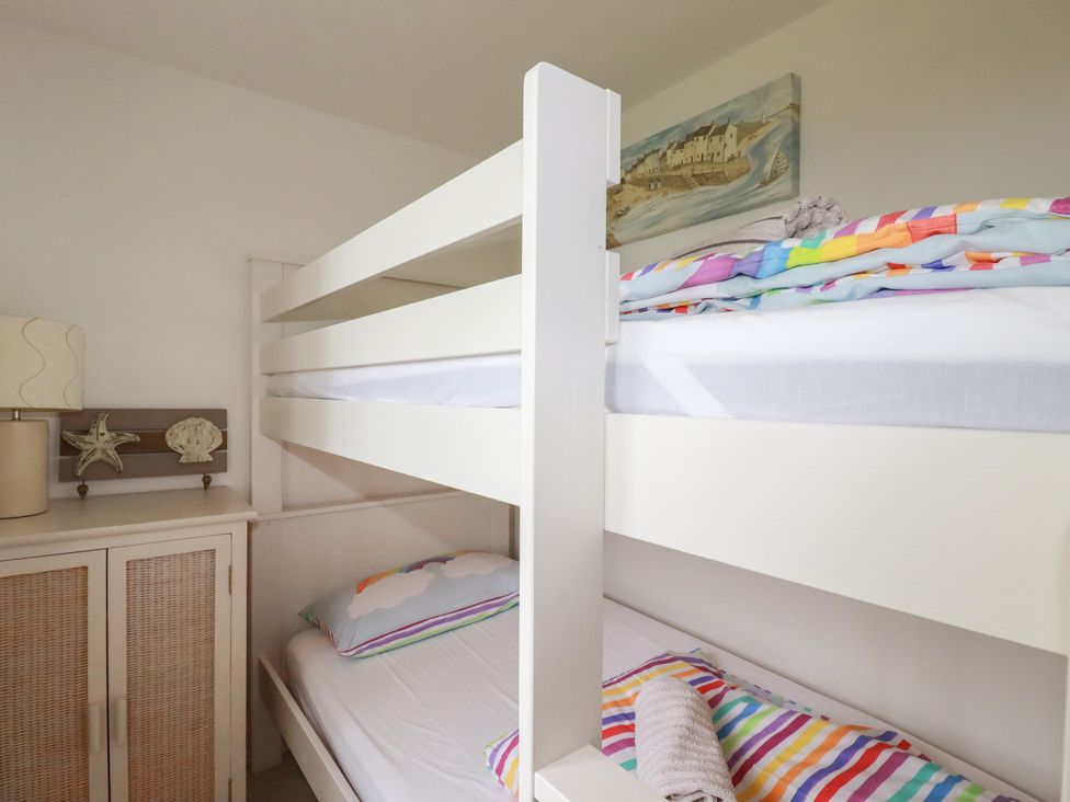 A bedroom with a bunk bed and nightstand at Atlantic View in Tintagel