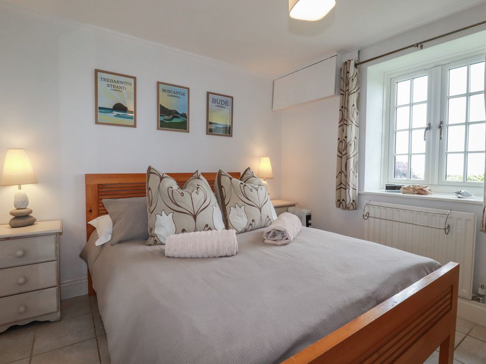 A bedroom with a bed and wall art at Atlantic View in Tintagel