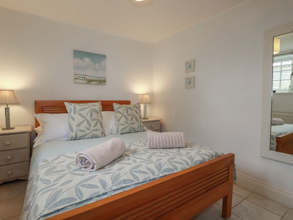 A bedroom with a bed and nightstands at Atlantic View in Tintagel